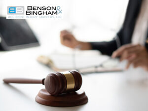 A wooden gavel on a table with a blurred Nevada personal injury lawyer working in the background
