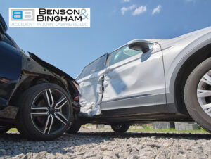 Two cars involved in a side collision accident on a gravel surface under a clear sky