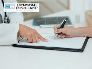 A person points to a section on a document that another person is preparing to sign, suggesting a detailed review, likely in a legal or medical context